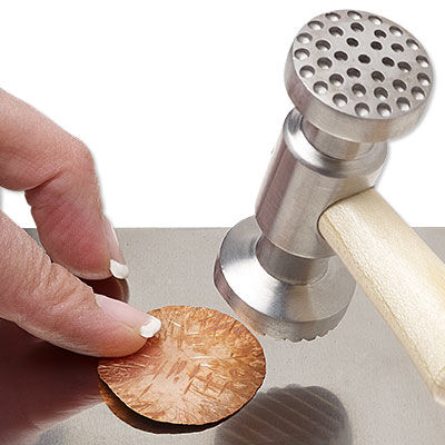 Metal being struck with a textured hammer